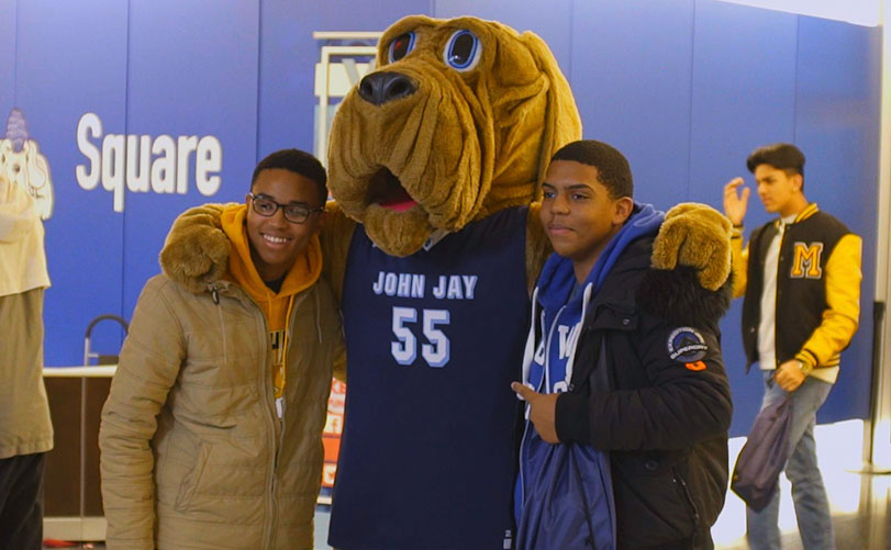 John Jay College mascot Bloodhound posing with students