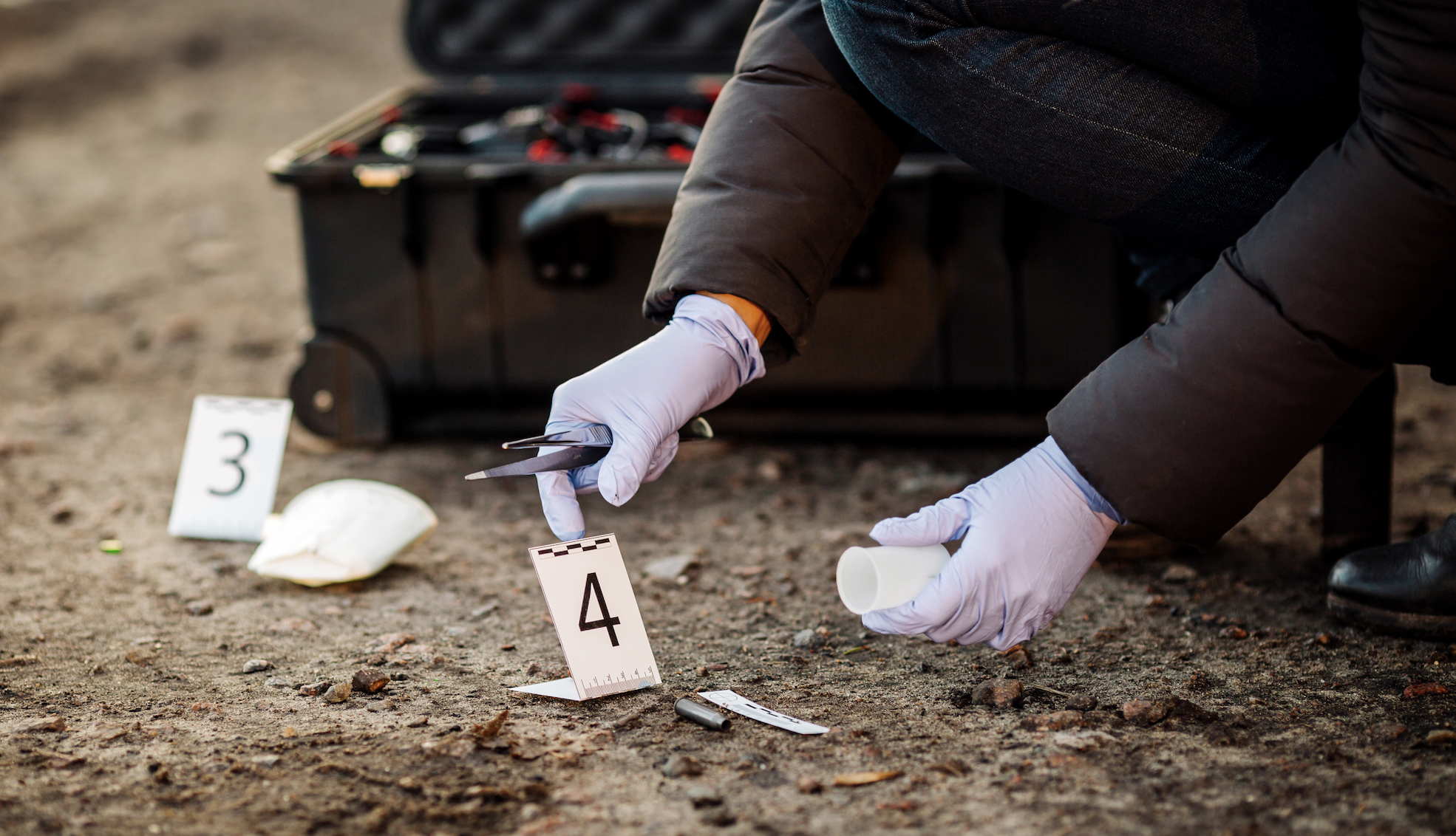 Image of a forensic scientist collecting evidence at a crime scene