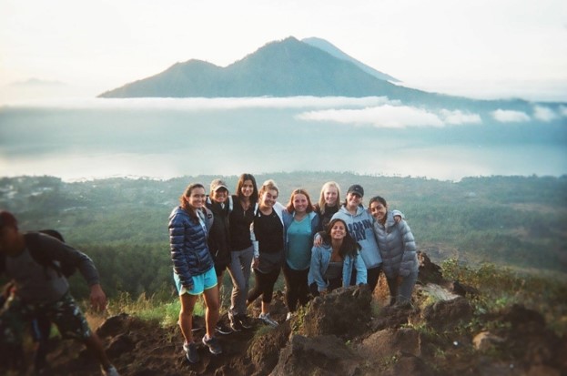 group of students standing in front of a mountain in Bali