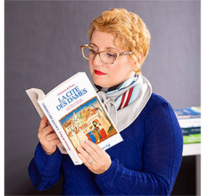 Woman in blue sweater reading a book