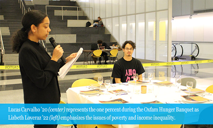 Lucas Carvalho ’20 (center) representing the one percent during the Oxfam Hunger Banquet as Lizbeth Loveraz ’22 (left) emphasizes the issues of poverty and income inequality