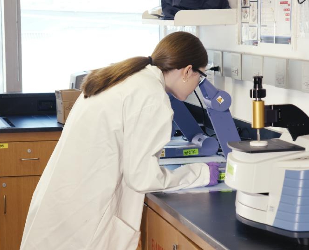 Image of a student wearing a lab coat in a lab
