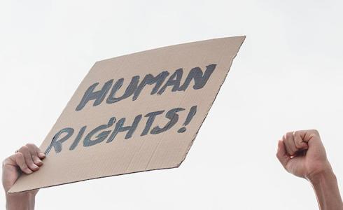 Hand holding a sign that says Human Rights