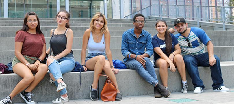 John Jay students sitting on the steps on the Jay Walk