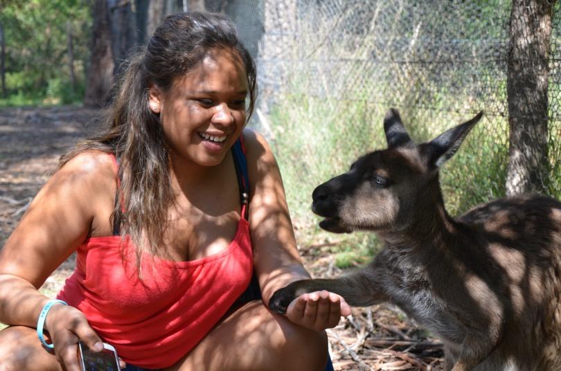 JJC student in Australia crouching next to a wallaby