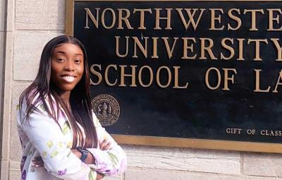 Jehovahnie Saint-Rose standing by Northwestern University School of Law sign