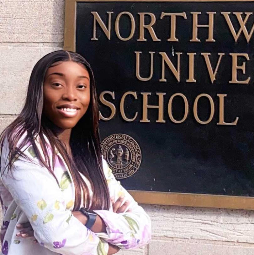 Jehovahnie Saint-Rose standing by Northwestern University School of Law sign